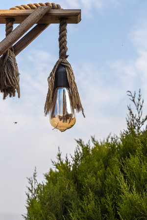 The led glass transparent lamp classic ball form with rope decor is on the wooden stand on the blue sky backgroundの写真素材
