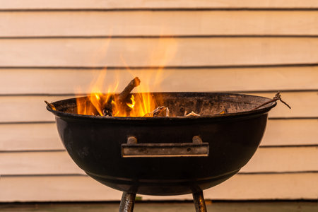 Black metal round barbeque with fire for a picnic is in the terraceの写真素材