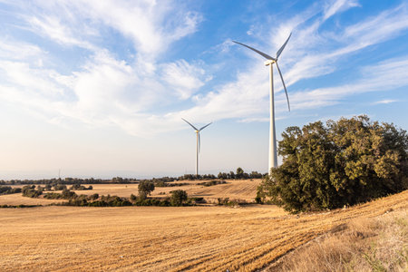 Group of white wind generators produces alternative energy by wind on the fields in Europe in Spain