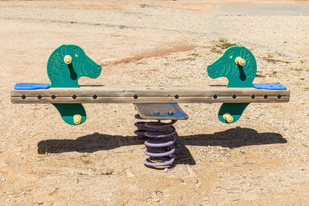 A Swing with green sea horses on a childrens playground in the courtyard in summerの写真素材