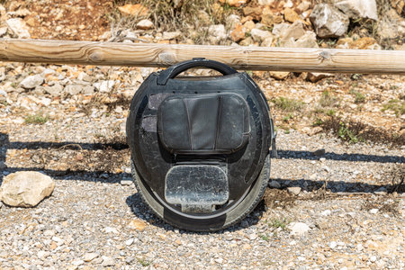 Electric unicycle leaning against wooden fence