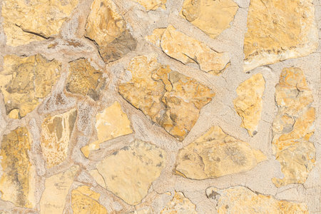 A beautiful texture of path or wall of orange and yellow stones is in the park
