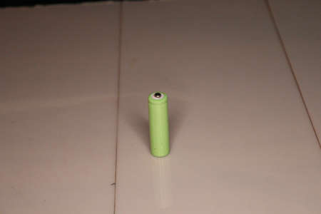 Green battery on the floor. Green battery on a white background.の写真素材