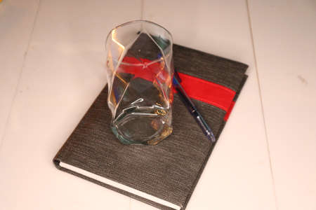A glass vase on a black book.の写真素材