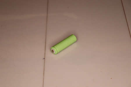 Green battery on a beige background. Green battery on a beige background.の写真素材