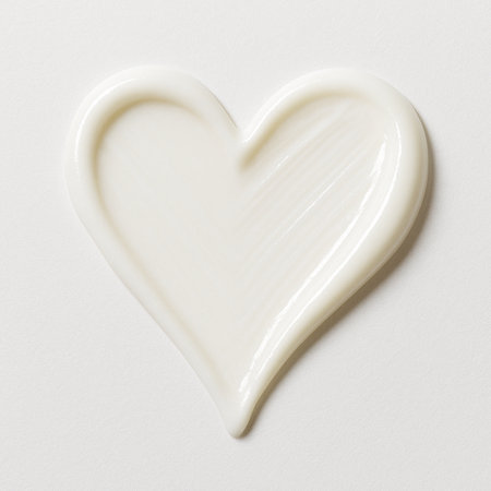 close up of a white chocolate heart shape on white paper backgroundの素材