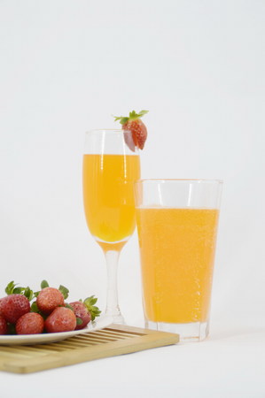 Fruit juice and a plate of strawberriesの写真素材