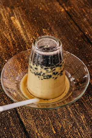 Coffee with milk and chocolate in glass cup on wooden backgroundの写真素材