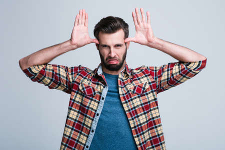 Take a look at yourself. Handsome young man making a face while standing against white backgroundの写真素材