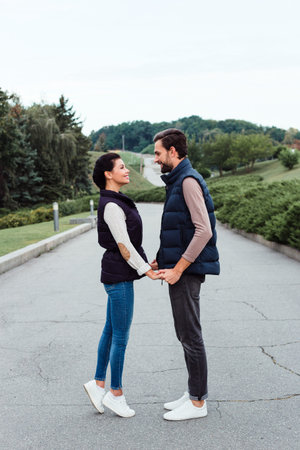 In love. Young beautiful couple bonding to each other while walking in the park in autumn
