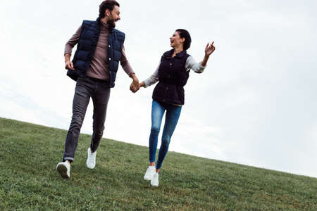 Fun and lovely. Young beautiful couple bonding to each other while walking in the parkの写真素材