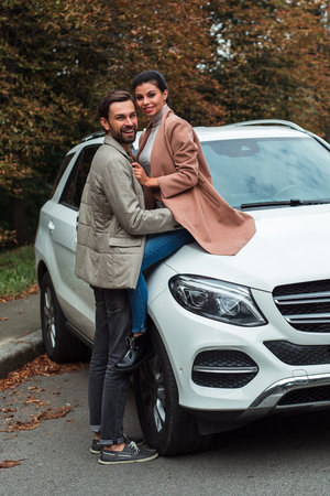 Little autumn trip is about to begin. Young beautiful couple bonding and looking at camera with...