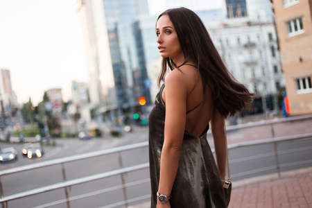 Time to conquer this city. Rear view of beautiful young woman in velvet dress looking away while standing outdoorsの写真素材