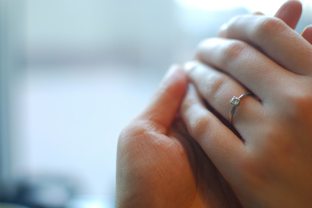 Hand holding another hand weating engagement ring.の写真素材