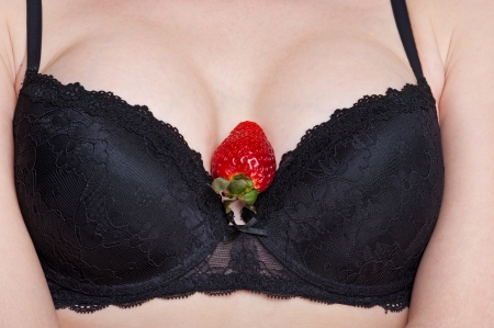 sweet strawberry lies between a woman s breastsの写真素材