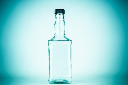 bottle for alcohol isolated on a blue backgroundの写真素材