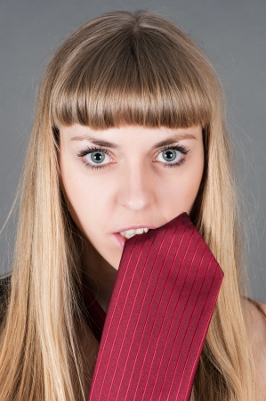 beautiful woman holds in teeth tieの写真素材