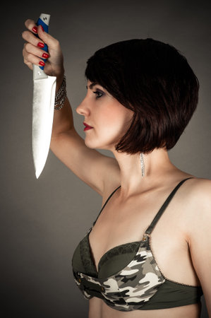 profile of beautiful woman with a knife in handの写真素材