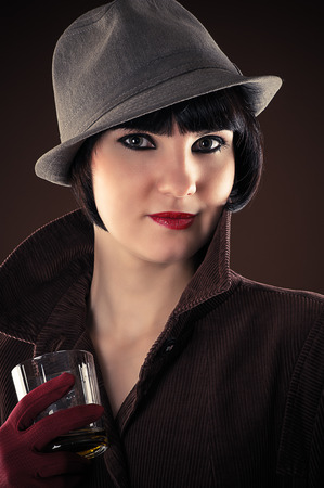 attractive female detective with a glass of whiskeyの写真素材