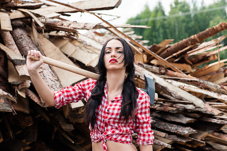 luxury sexy woman ax in hand in a plaid shirtの写真素材