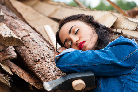 woman sleeping holding an ax in handの写真素材