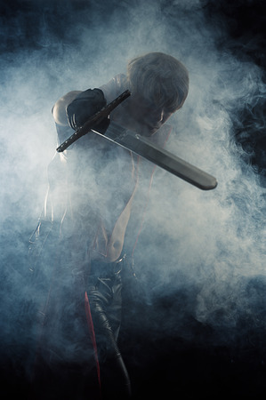 brutal man hit a sword in smokeの写真素材