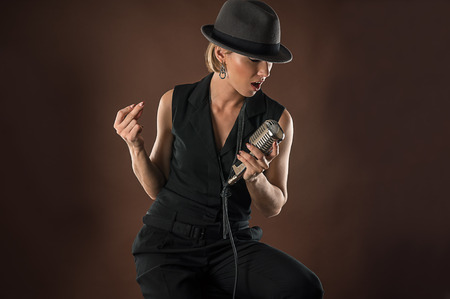 stylish woman in a hat with a retro microphoneの写真素材