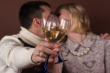 young couple kissing holding champagne glassesの写真素材
