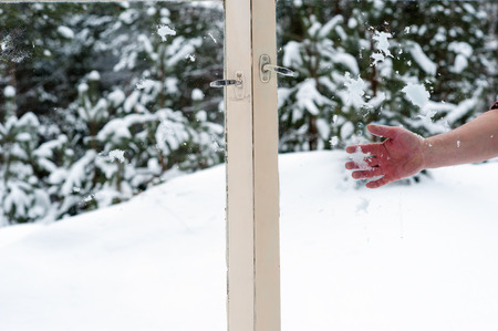 hand throwing snow in the wooden windowsの写真素材