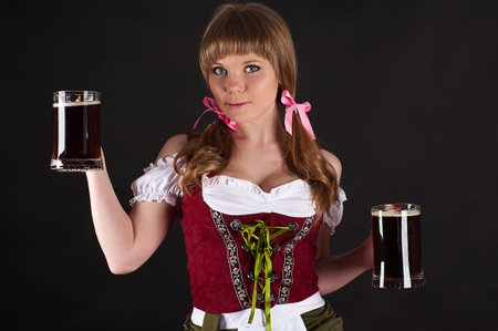 woman Oktoberfest with beer in hand isolated on blackの写真素材