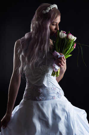 woman in wedding dress smelling wedding bouquet