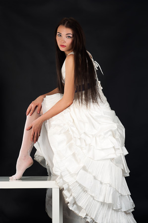 bride in a wedding dress straightens stockingsの写真素材