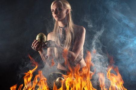 beautiful woman with a nest egg dragons in the fireの写真素材