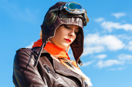 sadness woman in aviator helmet on the sky backgroundの写真素材