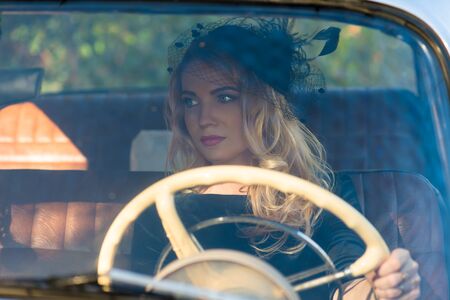 fashionable woman at the wheel of a retro carの写真素材