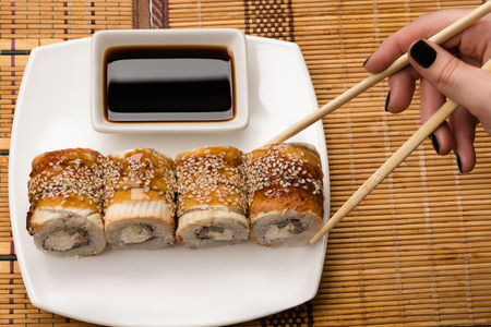 woman holding chopsticks rollの写真素材