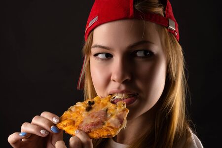 hungry young woman eating pizzaの写真素材