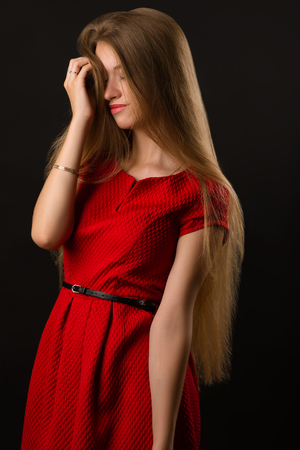 attractive young blond woman in red dressの写真素材