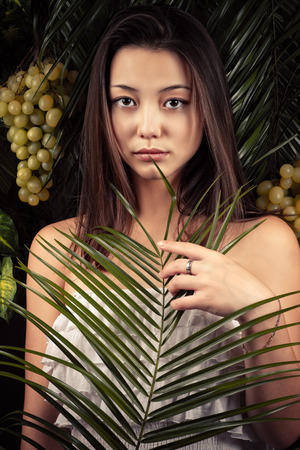 attractive girl with tropical leaves closeupの写真素材