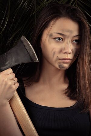 beautiful Korean girl with ax in handsの写真素材