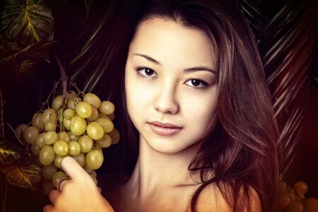 beautiful portrait girl with grapesの写真素材