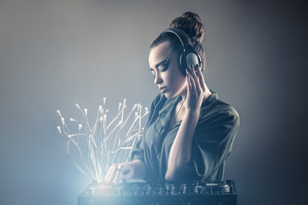 beautiful girl behind DJ remotes in headphonesの写真素材
