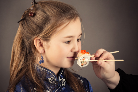 little charming girl eating roll humor portraitの写真素材