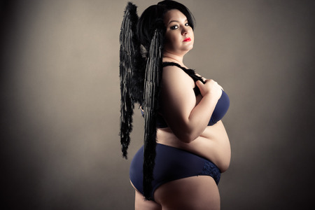 fat woman in lingerie with black wingsの写真素材