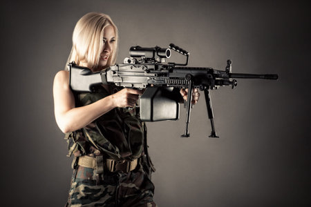 beautiful woman blonde aiming machine gun