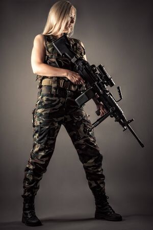 luxurious blonde in uniform with machine gun in handsの写真素材
