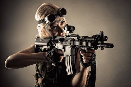 brutal blond woman with gun in handsの写真素材