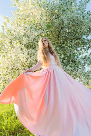 woman in a pink dress in gardenの写真素材