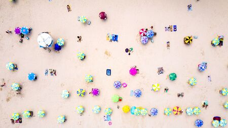 Top view on the beach full of colorful umbrellas, people during the sunny holidays.の写真素材