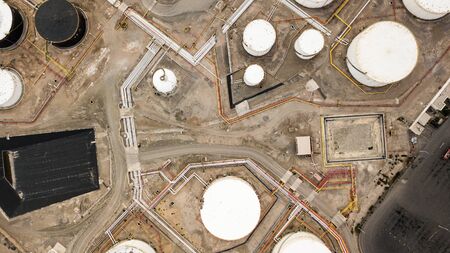 Aerial top down view on petroleum industrial factory, barrels, pipes, equipment parts at the sandy terrain creating an abstract forms and background.の写真素材
